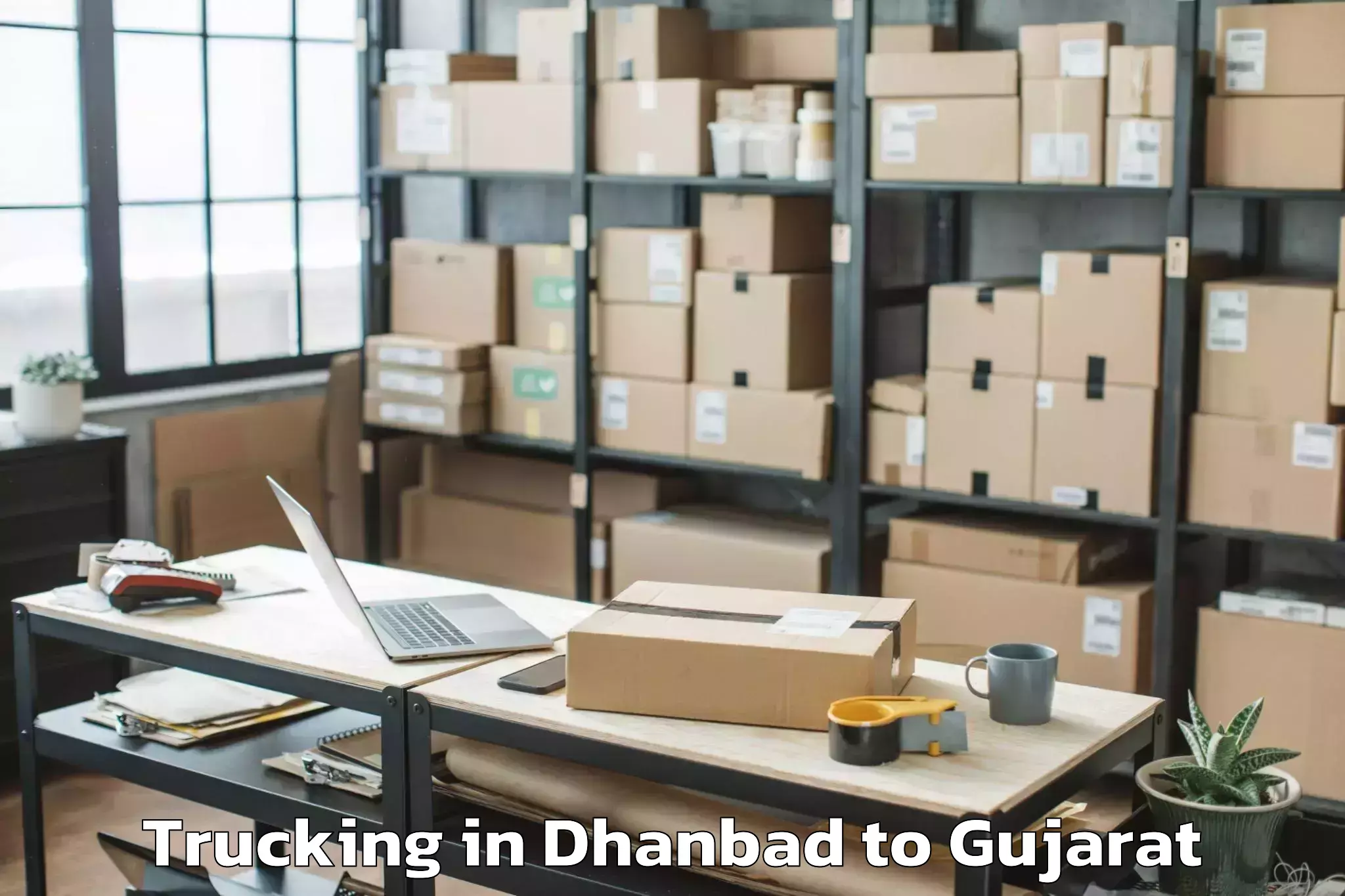 Trusted Dhanbad to Veer Narmad South Gujarat Univ Trucking